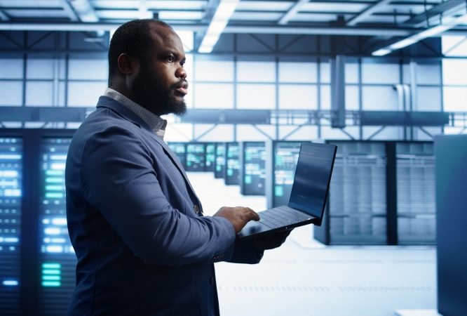 Technician in data center workspace running system diagnostic tests and error checking utilities to fix issues. Employee looks for network issues affecting rigs performance and connectivity, camera B