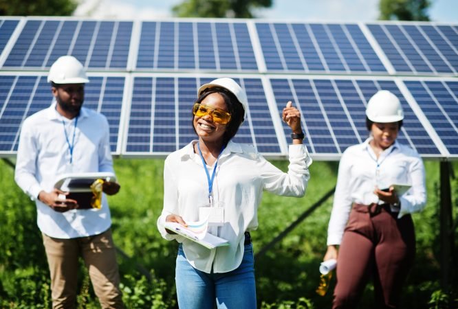 African american technician checks the maintenance of the solar panels. Group of three black engineers meeting at solar station.