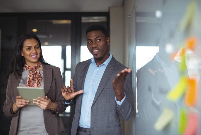Businessman discussing on white board with a colleague in office